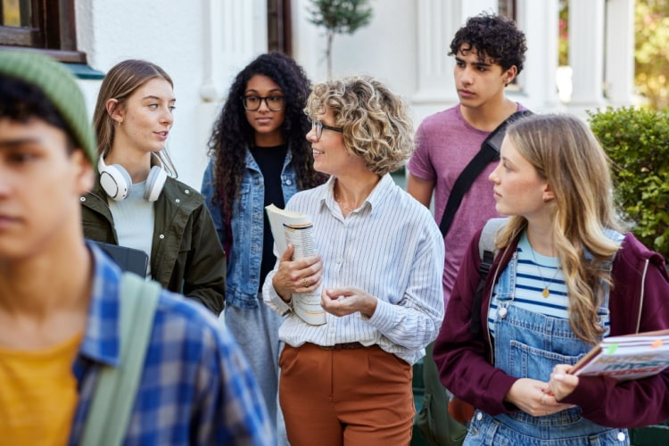 a group of high school students and their teacher outside on a field trip